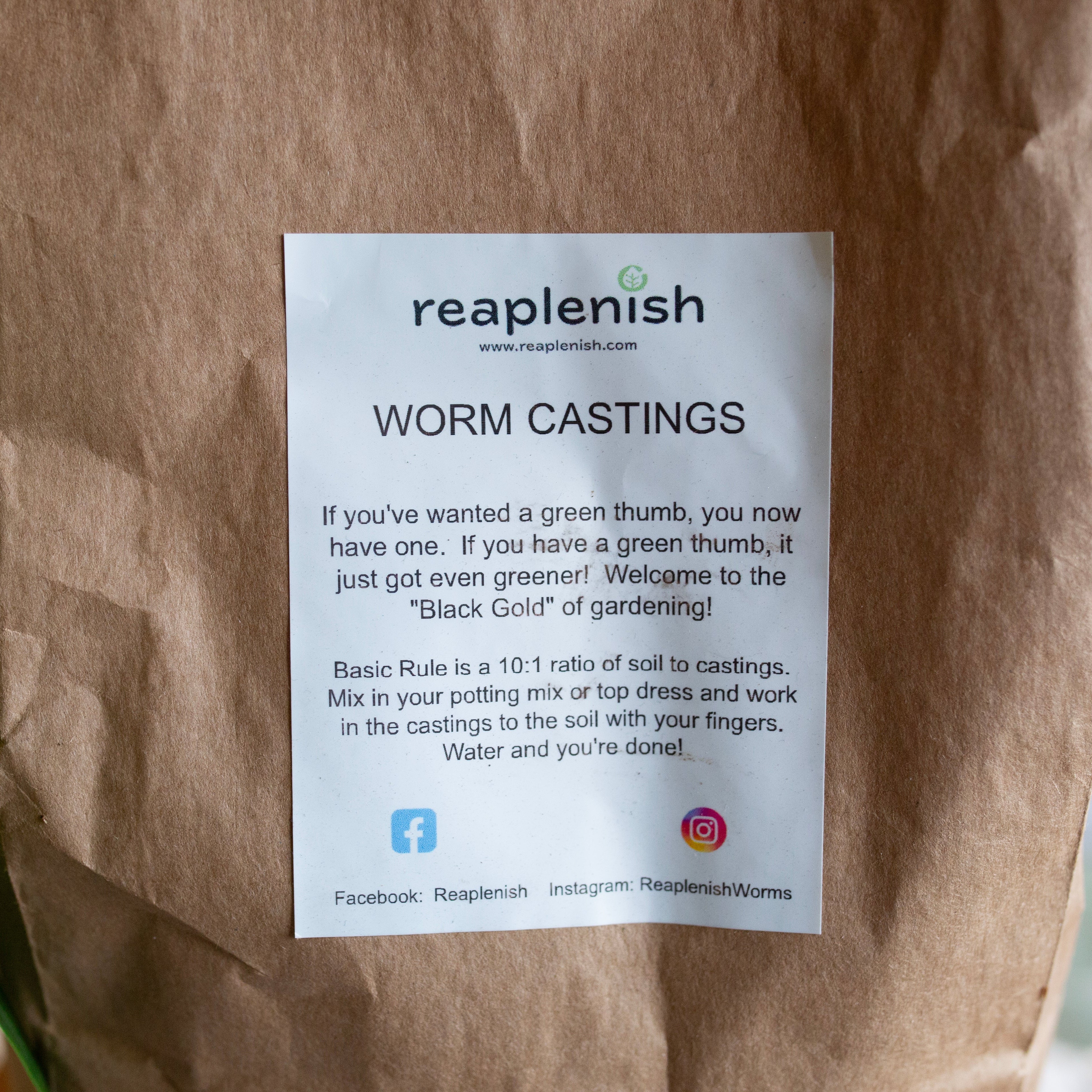 Close up bag of worm castings with a Reaplenish label whose contents are written in product's description on a blurred background 