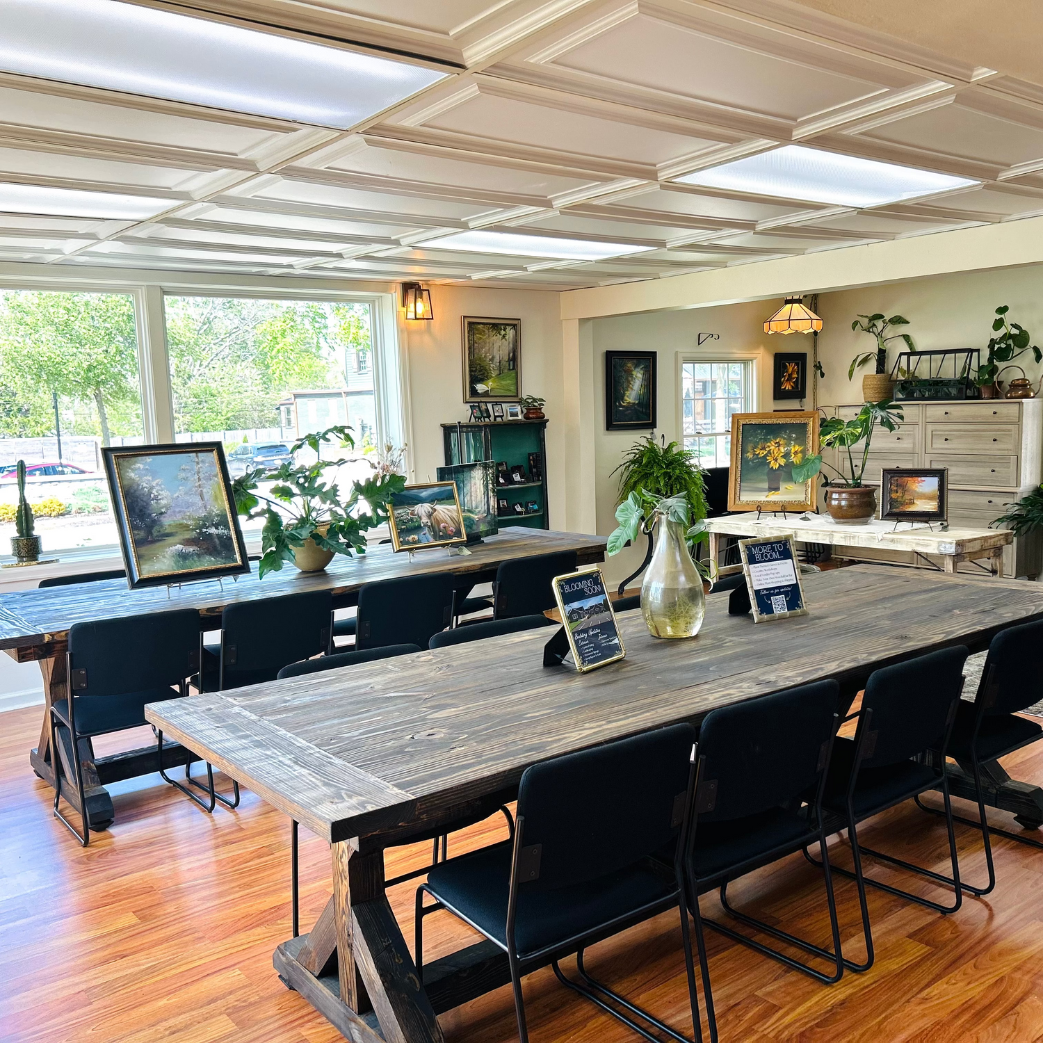 Our workshop fit with two large wooden table and chairs, plants, and artwork.
